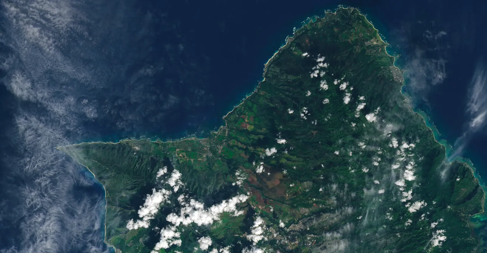 Aerial view of Oʻahu beneath scattered clouds