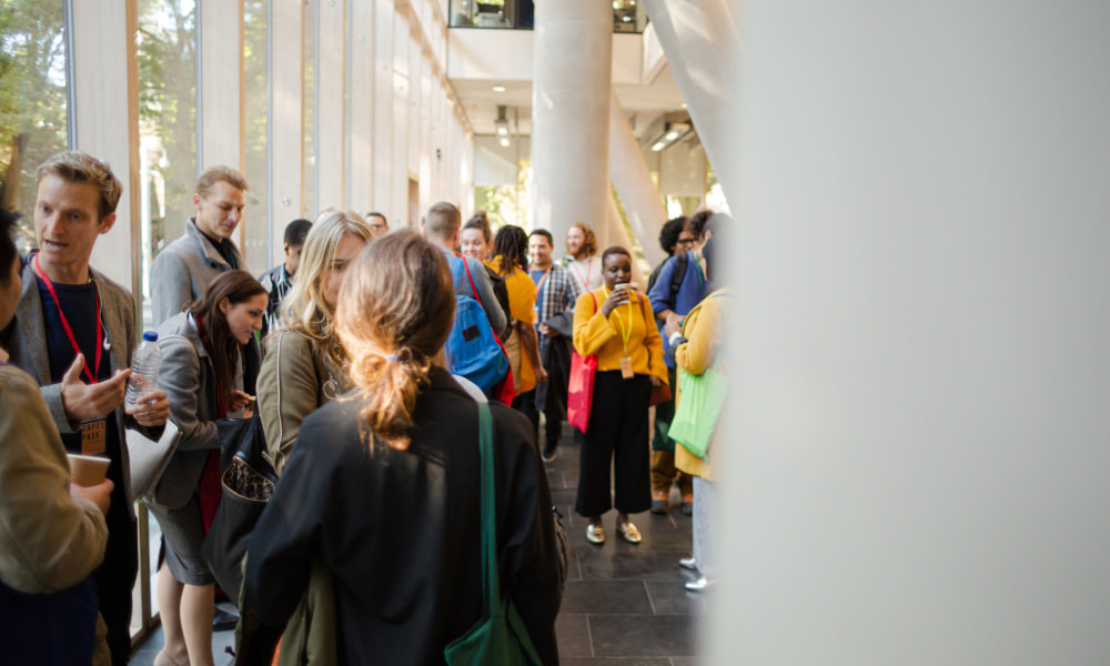 People gathering and talking in a bright hall