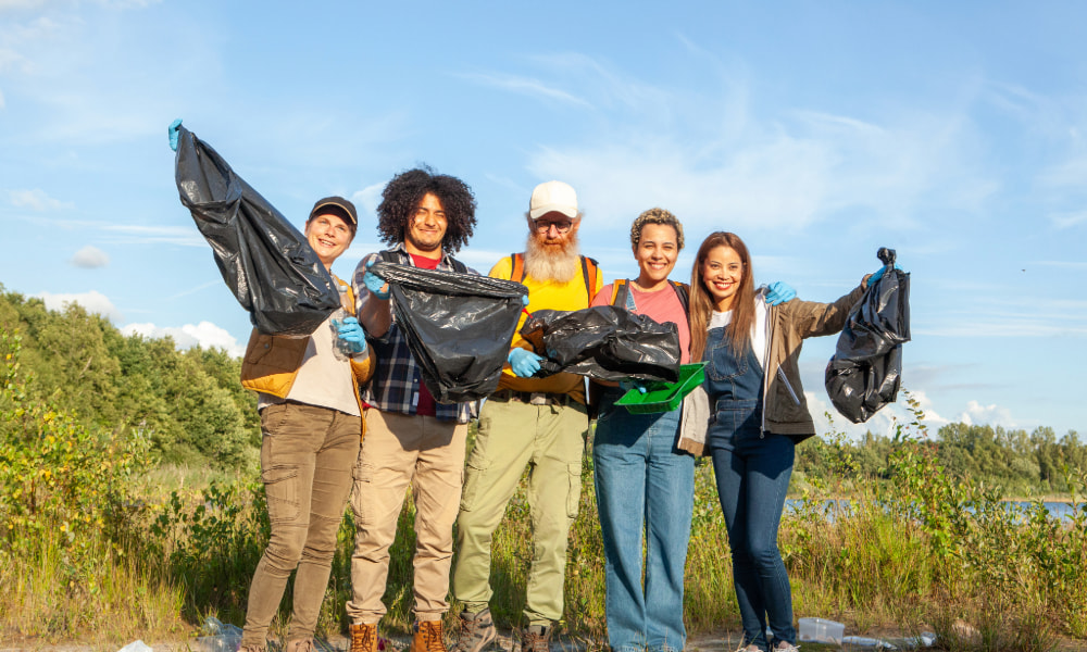 Volunteers holding bags after a shoreline clean-up