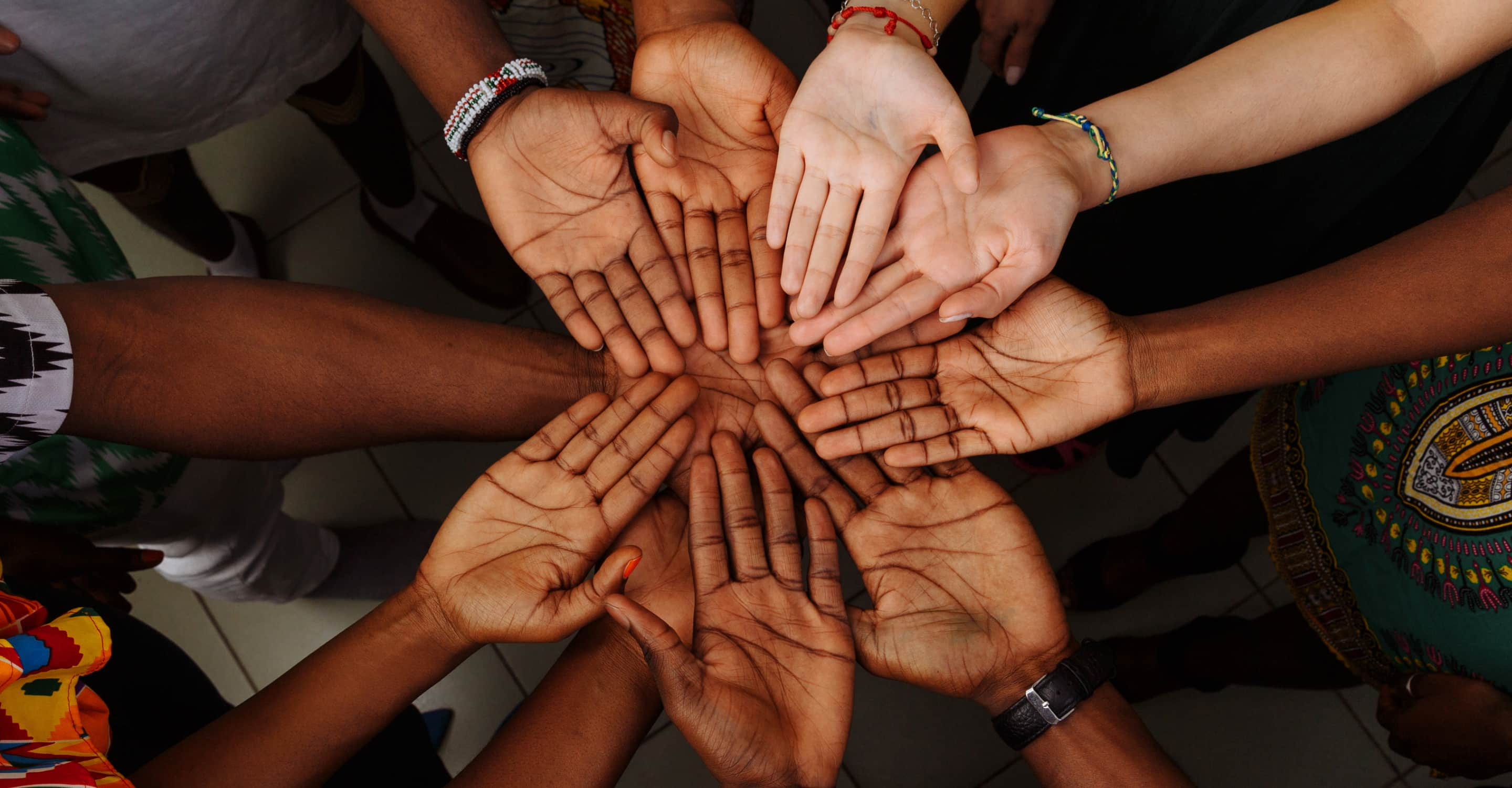 Hands joined over a table in the middle of a working conversation